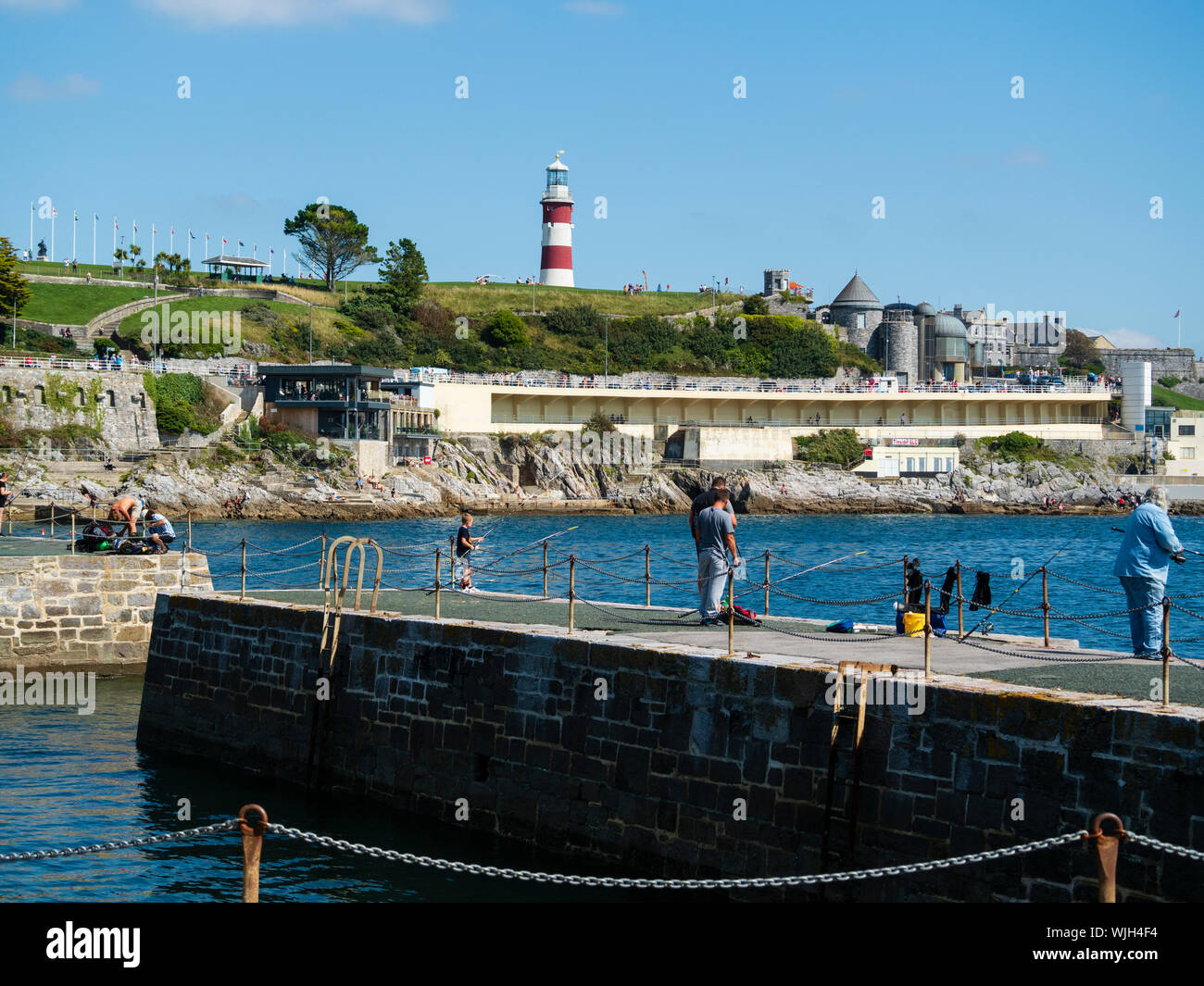Angler auf West Pier, Plymouth, Devon, UK Hoe, vor dem Hintergrund der Plymouth Hoe und Smeaton's Tower Stockfoto