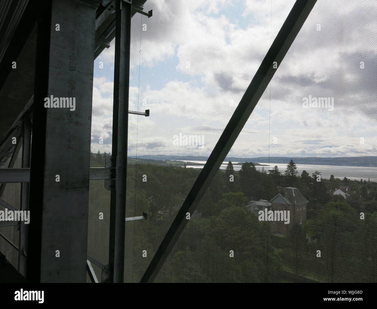 Blick auf den Firth of Clyde durch die chainmail Netz Schutz, Helensborough Hill's Haus Dach und Wände. Stockfoto