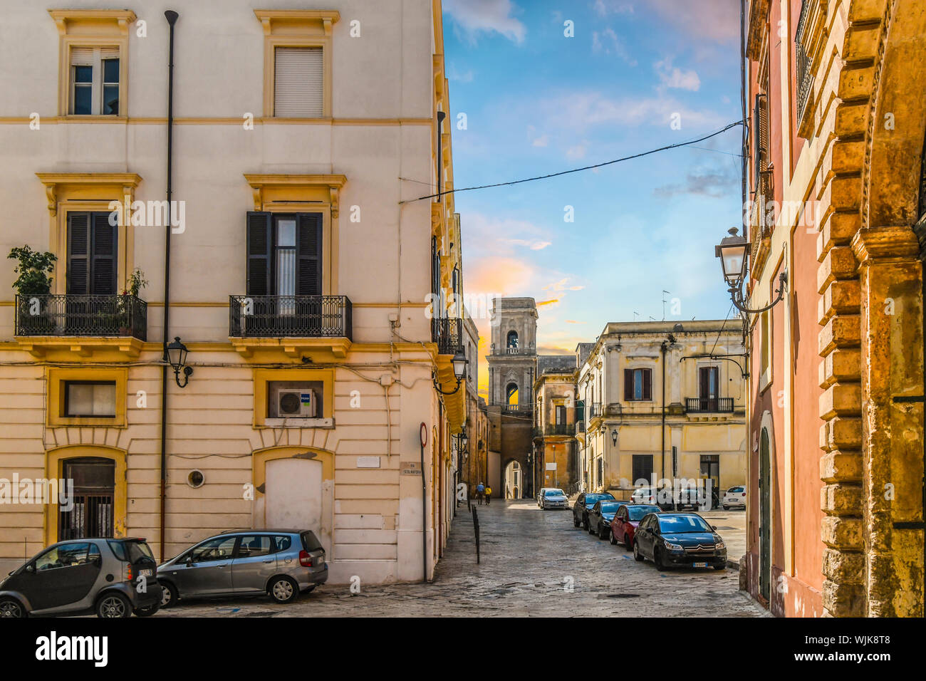 Ein paar ist in der Ferne, wie Sie in der Nähe einer mittelalterlichen Kirche Turm im historischen Wohnviertel von Brindisi, Italien gesehen. Stockfoto