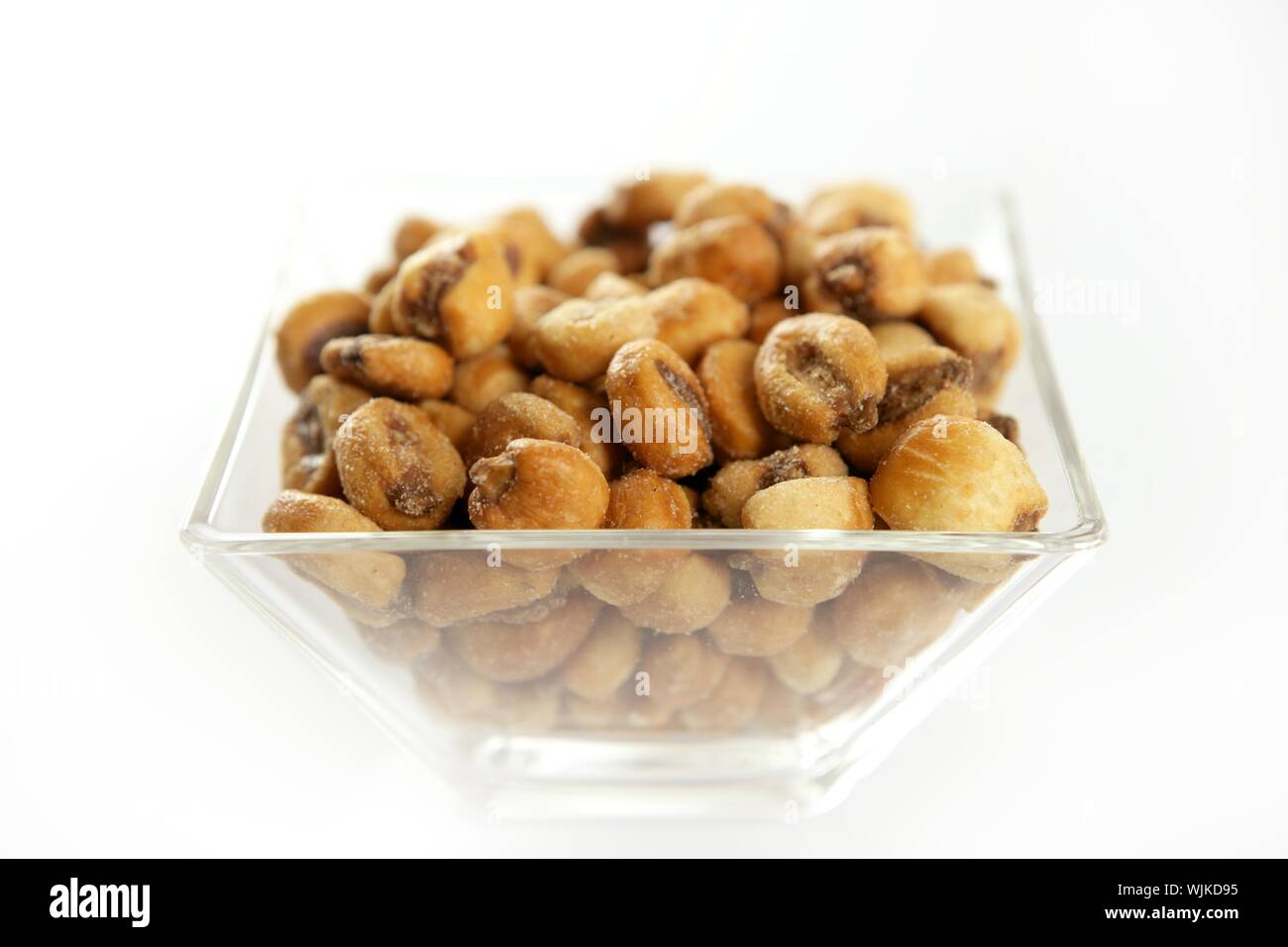 Roastwed gesalzen Mais in einem transparentem Glas Schüssel, weißen Hintergrund Studio-Shooting Stockfoto