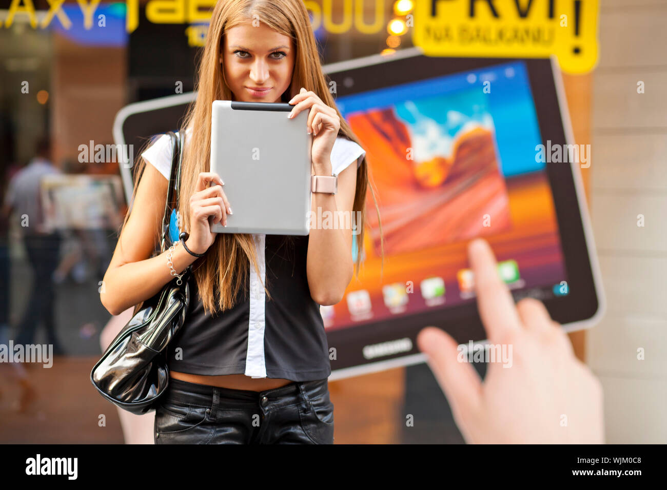 Junge Frau mit Tablet-PC zu Fuß auf der Straße Stockfoto