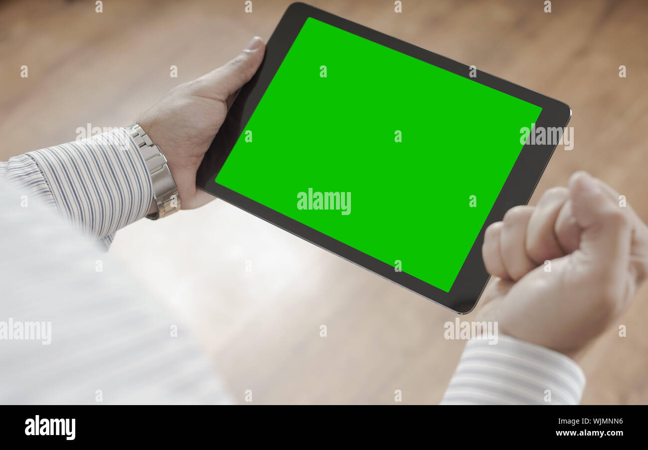 Männliche Hände, die Tablette mit Green Screen - erfolg konzept Man Feiert Stockfoto