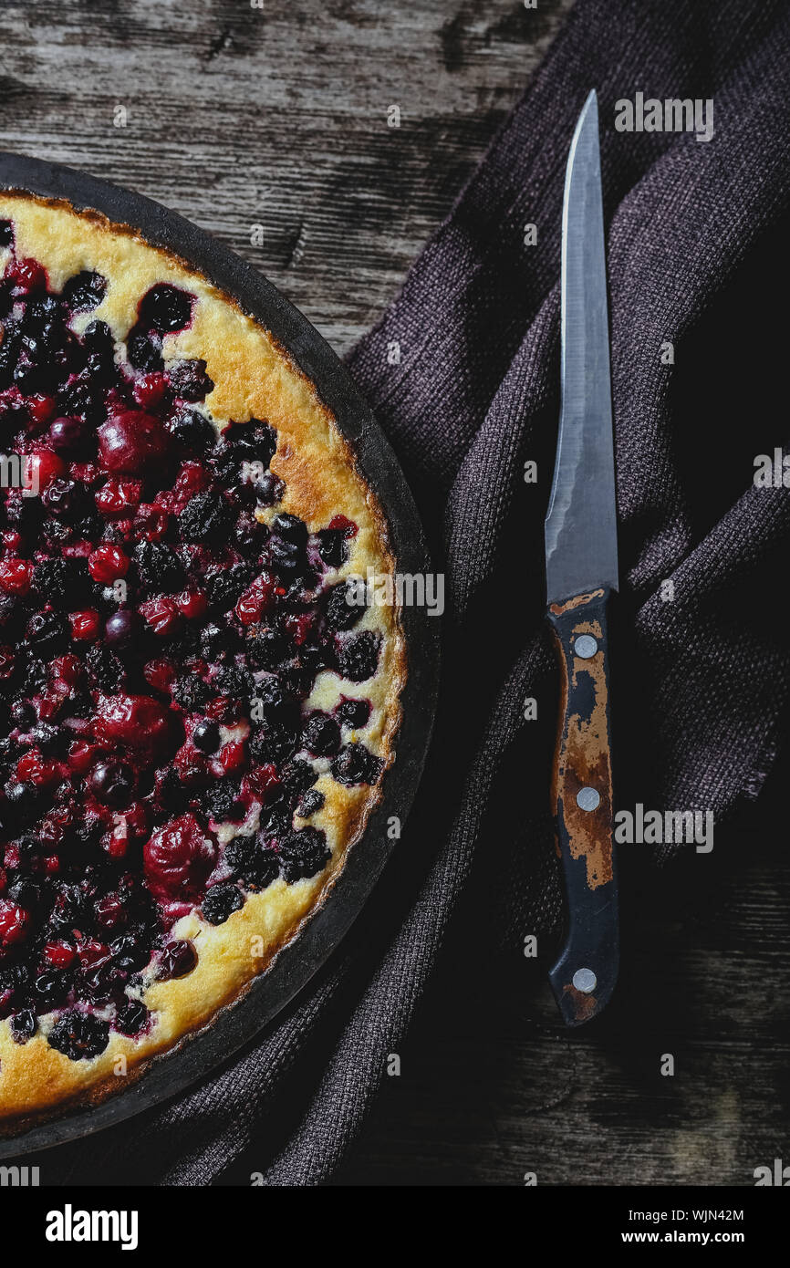 Berry pie mit Kirsche, Johannisbeere, Brombeere, Heidelbeere auf Holztisch im rustikalen Stil. Käsekuchen, Ansicht von oben. Stockfoto