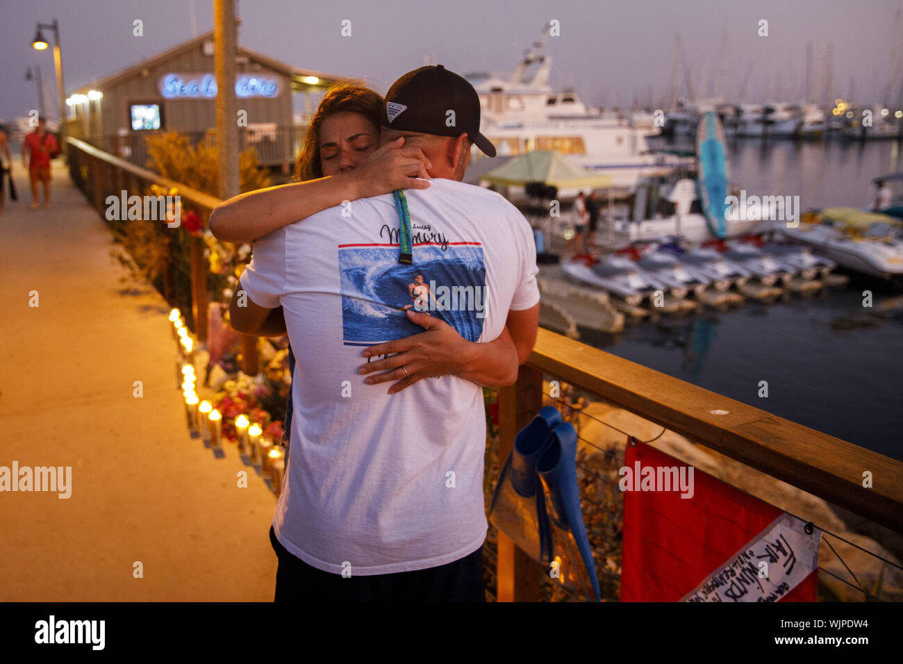 Santa Barbara, CA, USA. 2. Sep 2019. Jenna Marsala, 33 von Santa Barbara, Umarmungen JJ Lambert, 38, nachdem Sie einen Tauchgang Flagge an einem provisorischen Denkmal am Meer Landung in Santa Barbara Hafen hing nach der Konzeption tauchen Boot Brand in den frühen Morgenstunden bei Santa Cruz Insel am Montag, den 2. September 2019 in Santa Barbara, Calif. Lambert sagte, erinnerte er sich an das Tauchen als Kind von der Empfängnis. 30 - neun Menschen an Bord der Konzeption, als das Feuer ausbrach, mit nur fünf Besatzungsmitglieder überleben und 34 Tote befürchtet. © 2019 Patrick T. Fallon (Credit Bild: © Patrick Fallon/ZUMA Wir Stockfoto