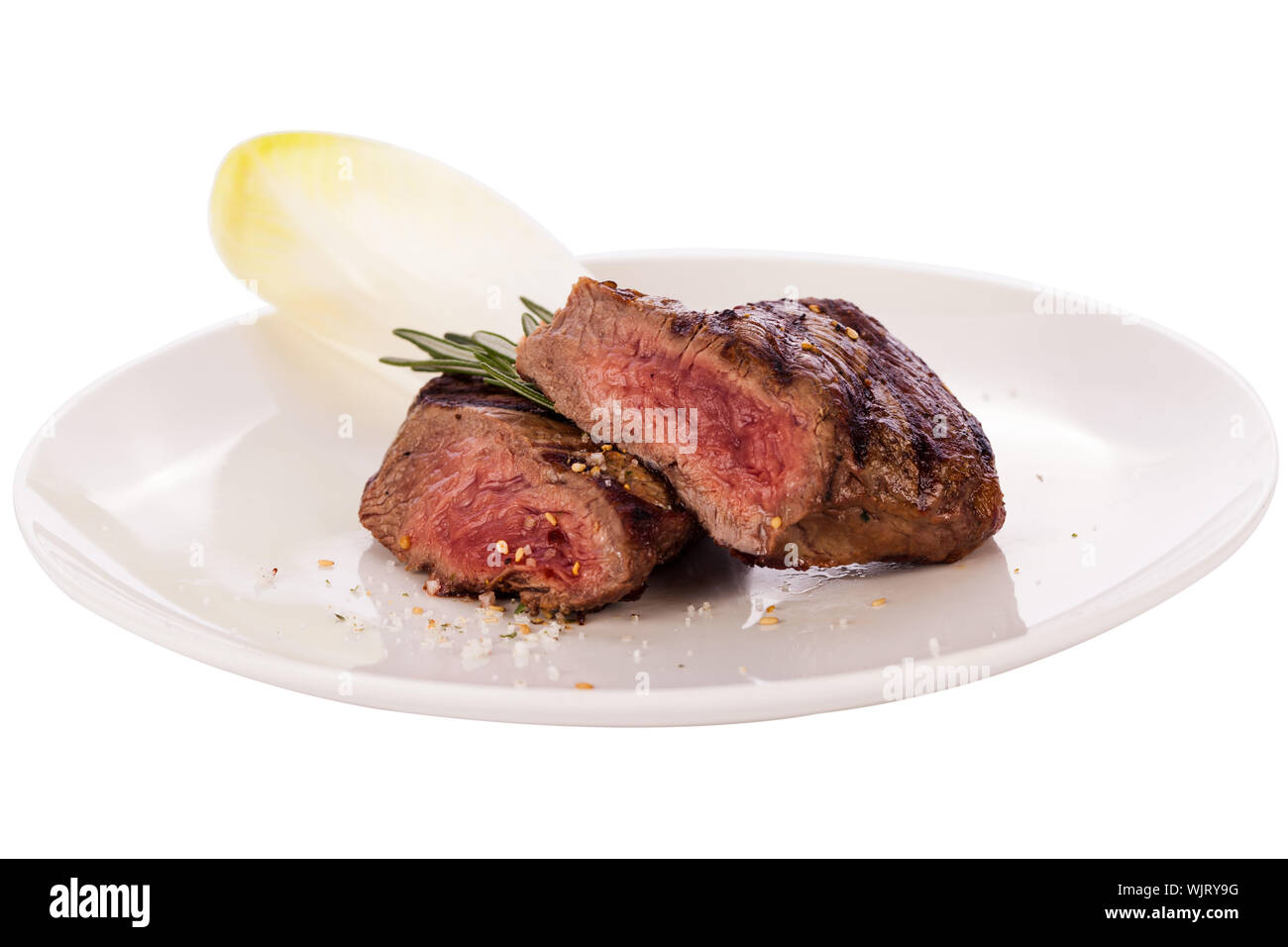 Saftige mittelgroße seltene Beefsteak in Scheiben geschnitten durch Anzeigen das zarte Fleisch und gewürzt mit Gewürzen und frischen Rosmarin, Nahaufnahme Stockfoto