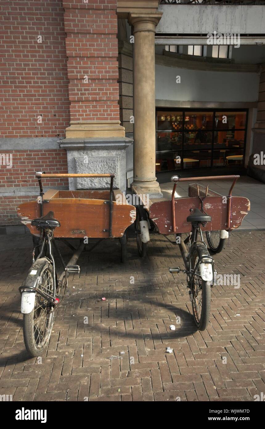 Zwei antike Fahrradanhänger für den Transport von Lebensmittel, geparkt und  das Dach von einem Bahnhof in Holland Stockfotografie - Alamy