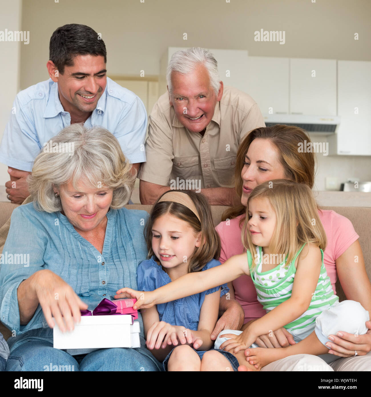 Lächelnd multigeneration Familie mit Geschenken im Wohnzimmer Stockfoto