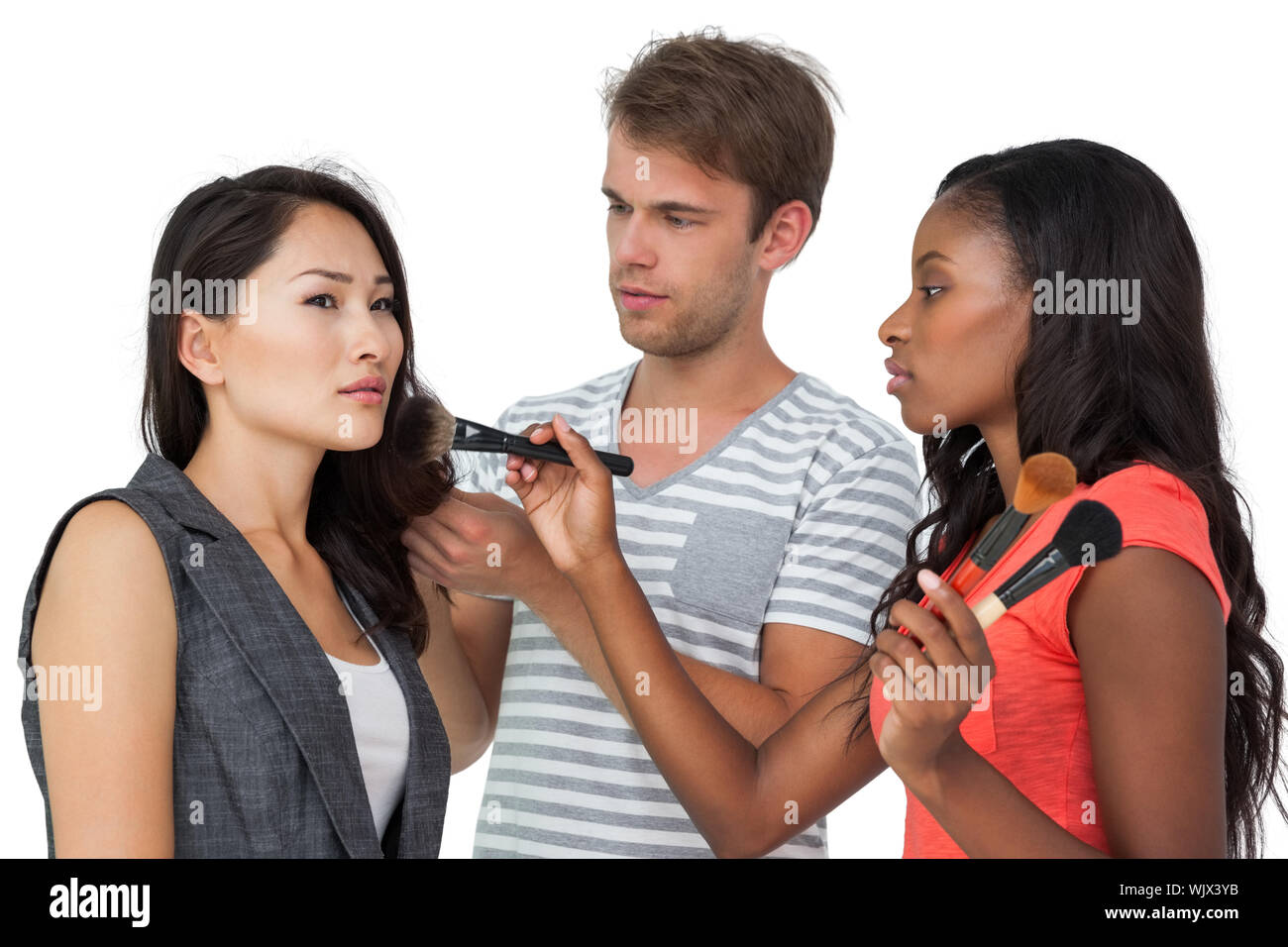 Assistenten der Anwendung Make-up für die weiblichen Modell auf weißem Hintergrund Stockfoto