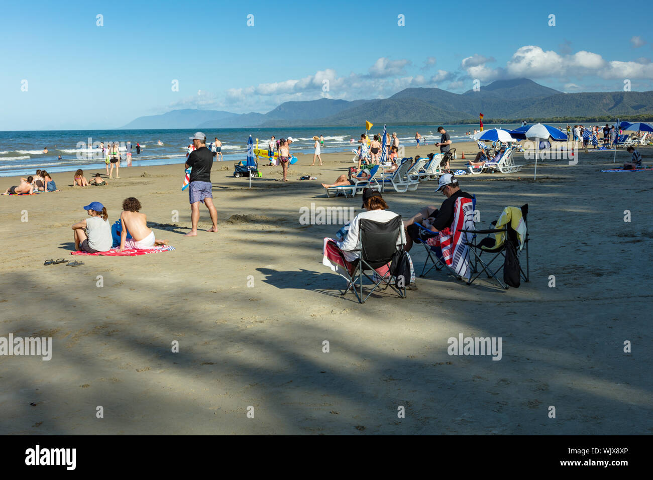 Port Douglas, Queensland, Australien. Four Mile Beach in Port Douglas mit der dramatischen Kulisse der Wolke bedeckte Berge im tropischen Norden Königin Stockfoto