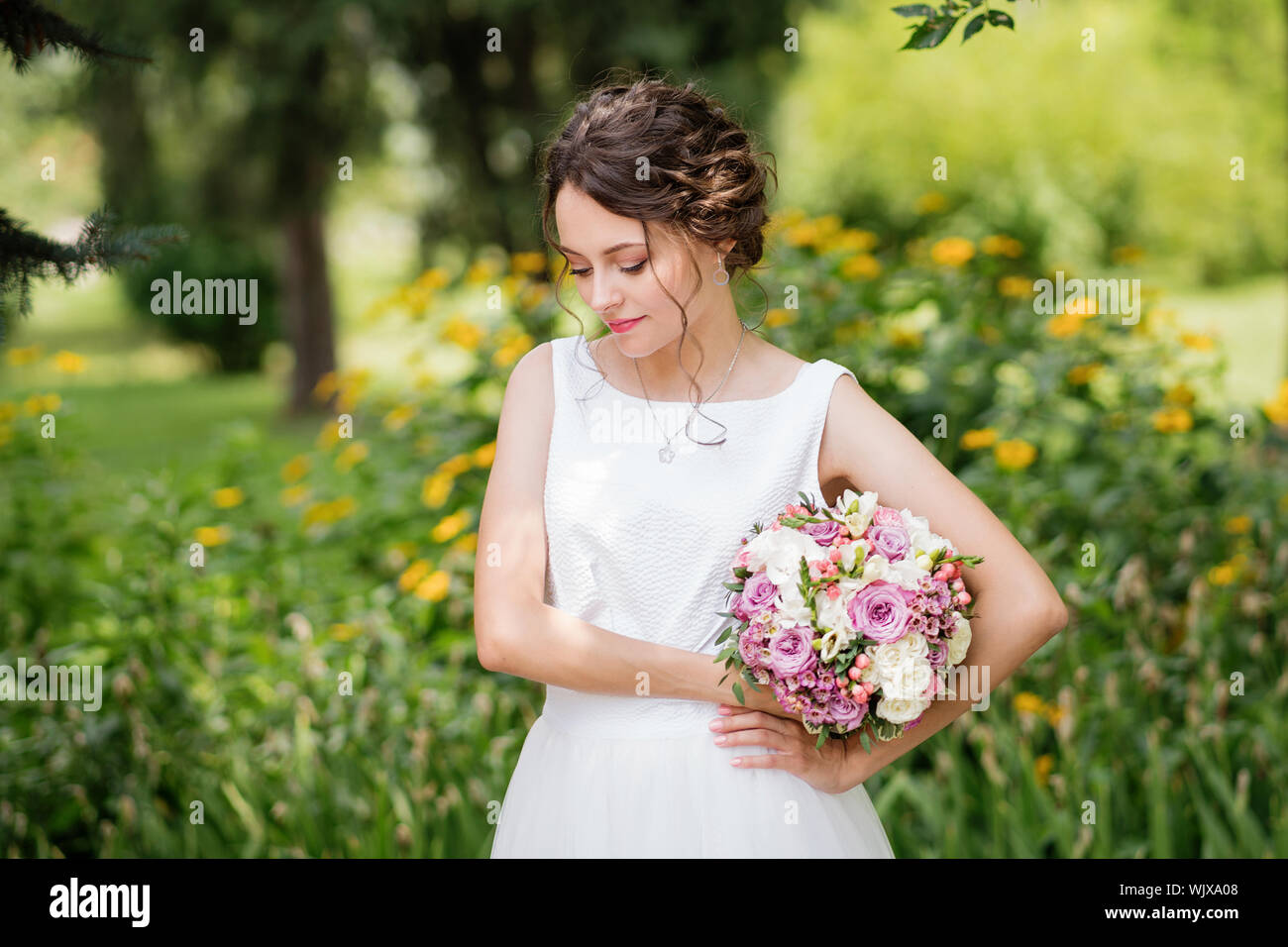 Schöne Braut in der Mode Hochzeit Kleid auf die natürlichen Hintergrund. Die atemberaubende junge Braut ist unglaublich glücklich. Hochzeitstag. Eine schöne Braut portrait Stockfoto