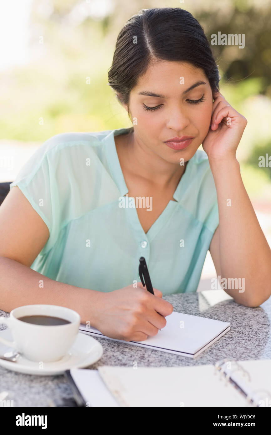 Seriöse Geschäftsfrau Kaffee und ihre Woche planen in Terrasse des Restaurants Stockfoto