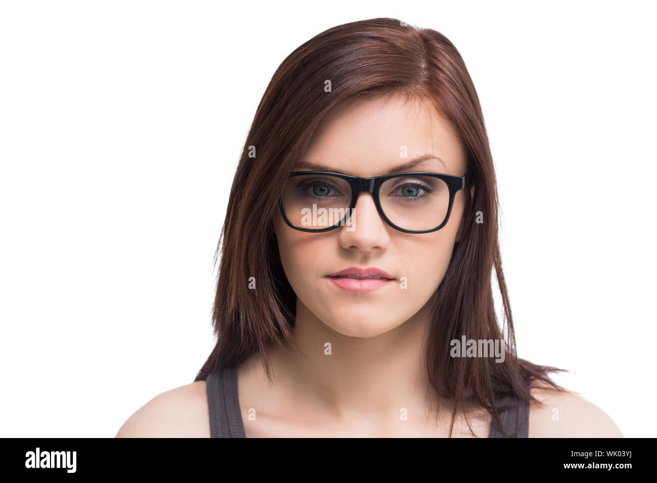 Ernste junge Frau mit Brille posiert Stockfoto
