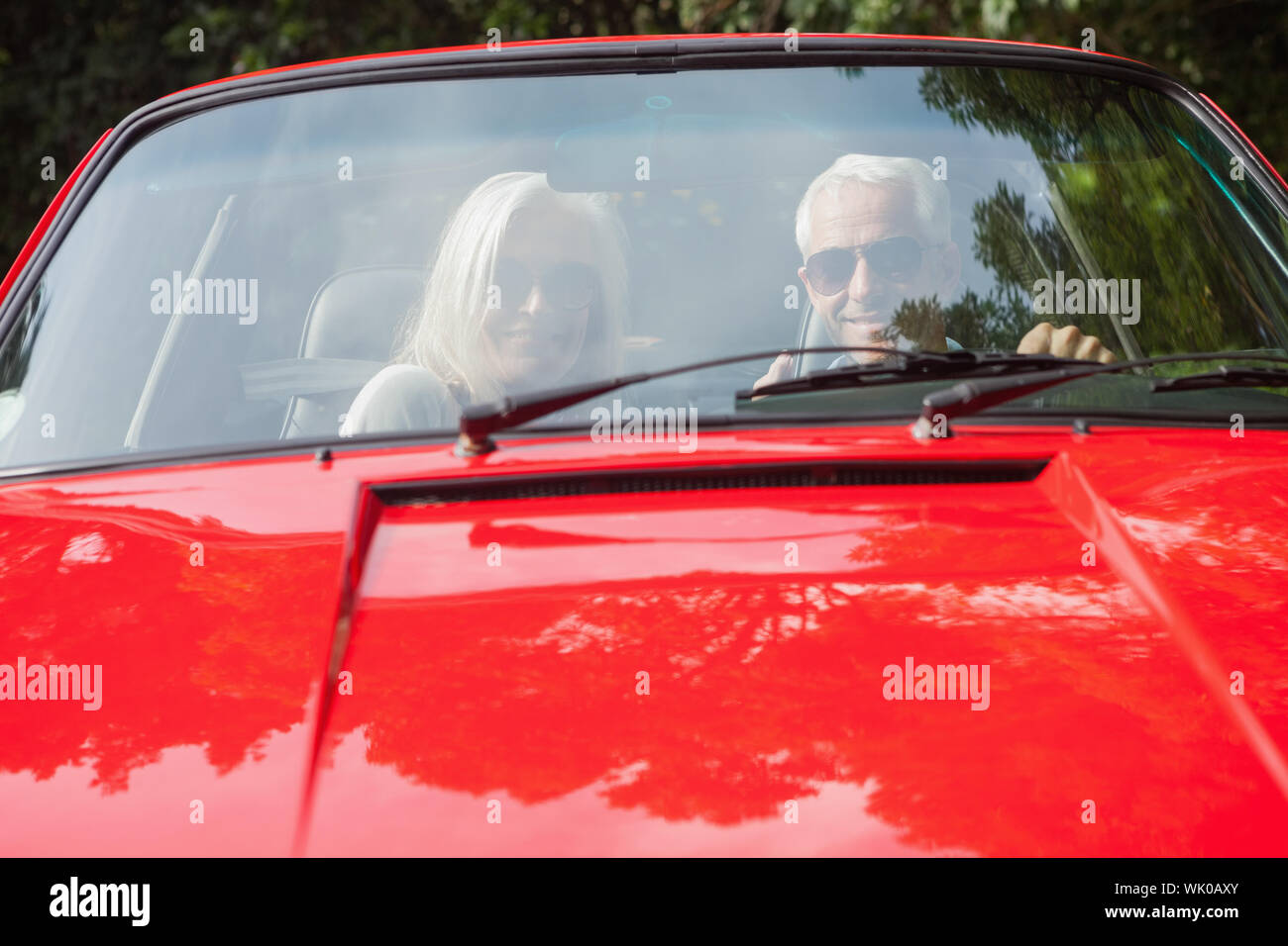 Älteres Paar in roten Cabriolet lächelnd Stockfoto