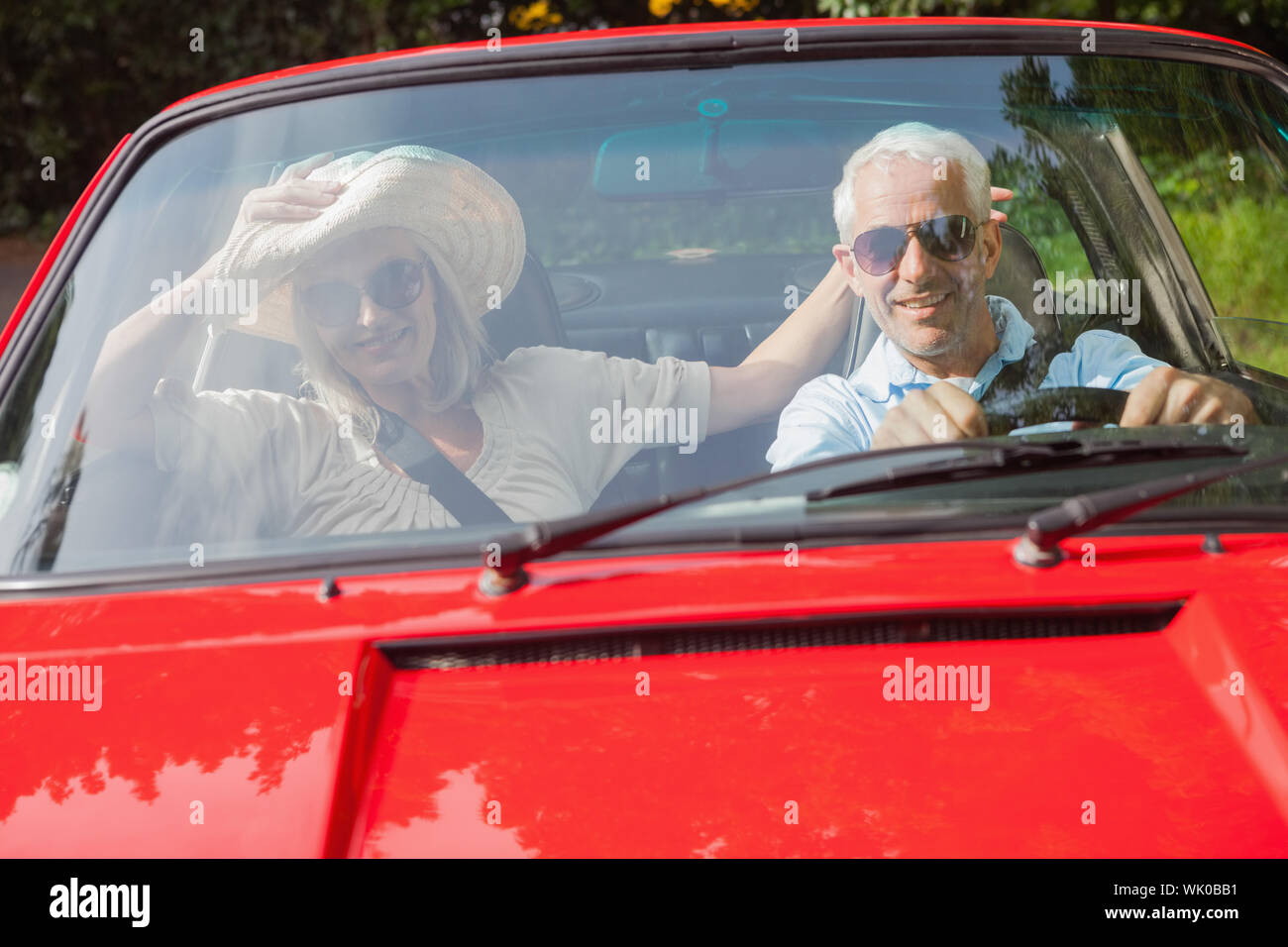 Fröhliche älteres Paar im roten Cabrio Stockfoto