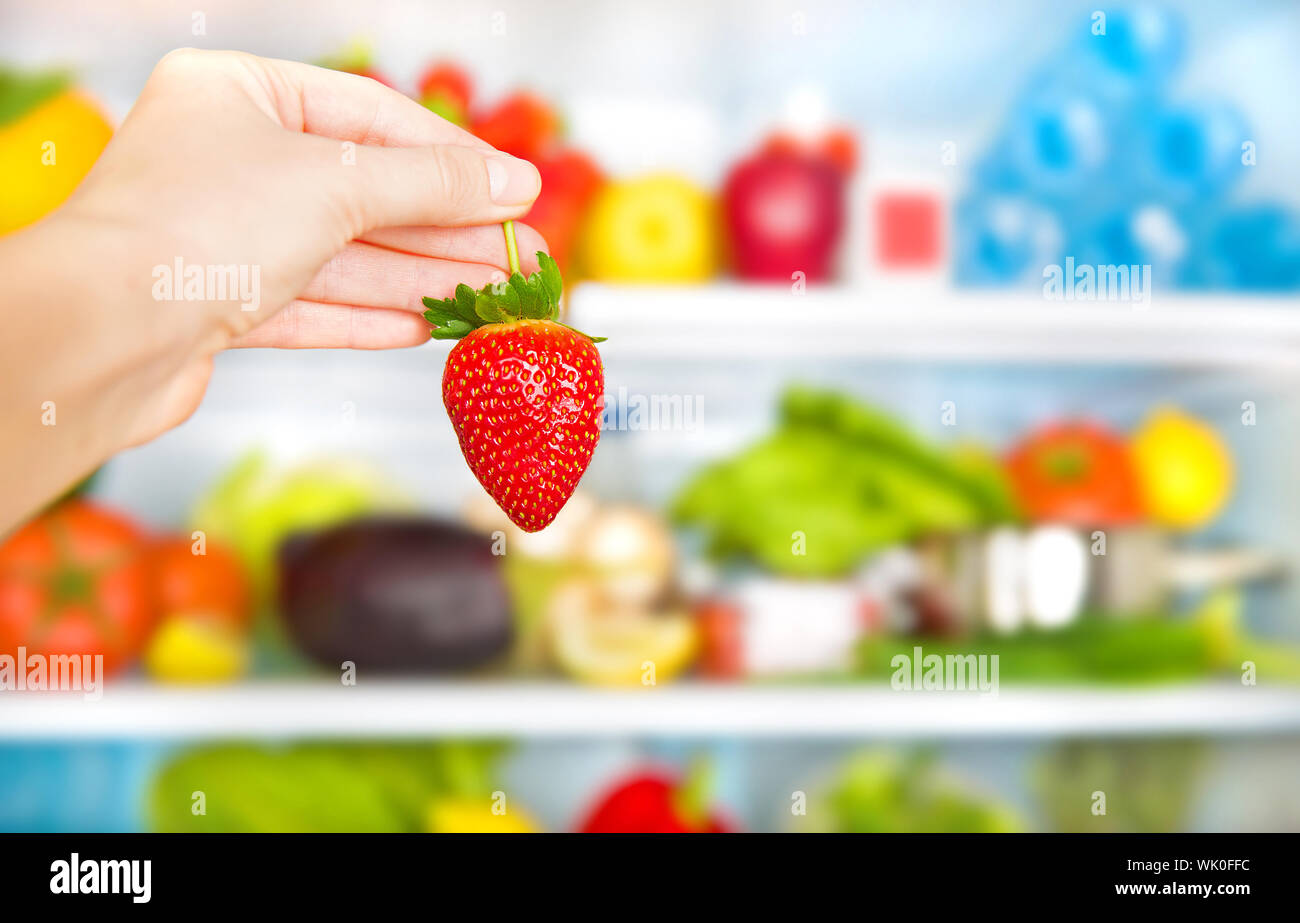 Das Essen gesund essen konzeptionelle Hintergründe, Gewichtsverlust und  Body Care Konzept, frische Erdbeeren in den Händen, voller Kühlschrank der  Ernährung Ernährung, selektive Schwerpunkte Stockfotografie - Alamy