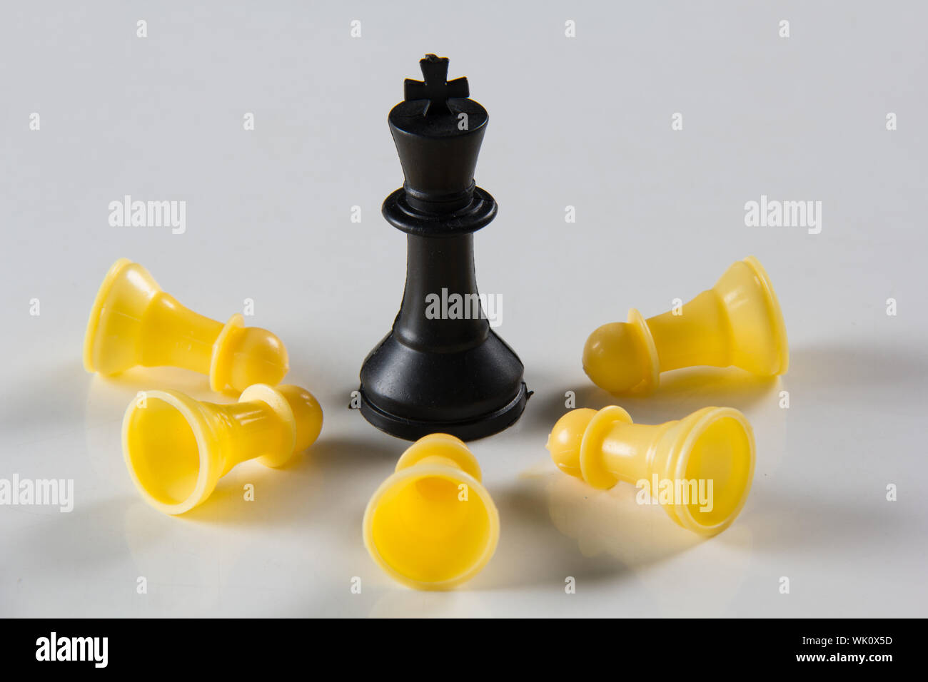 Schwarzer König besiegen weiße Schachfiguren Stockfoto