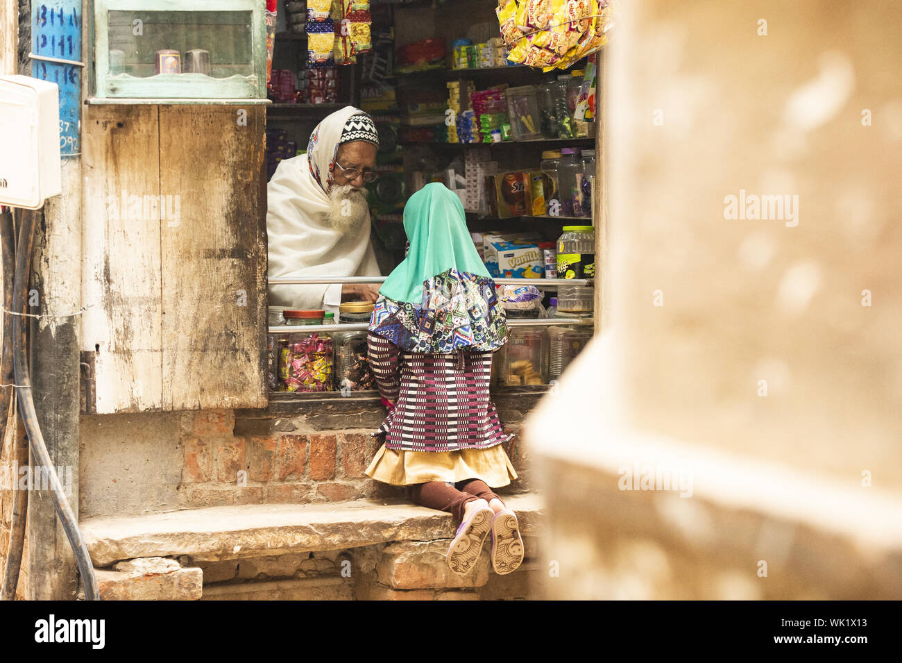 Ein indisches Kind kauft Süßigkeiten von einem Shop in den Straßen von Varanasi. Stockfoto