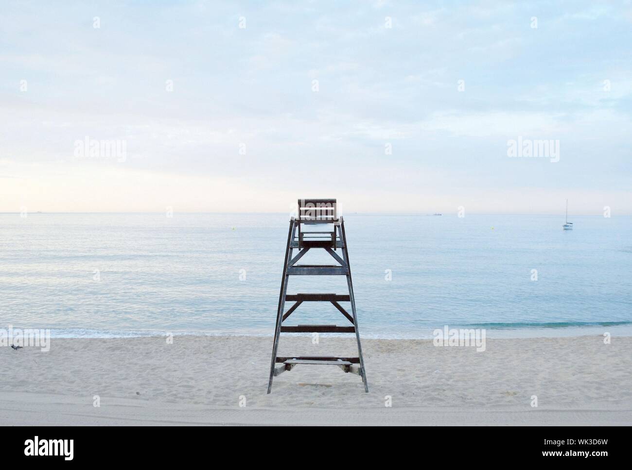 Nahaufnahme eines Rettungsschwimmersessels an einer Strandküste Mit einem bewölkten Himmel im Hintergrund Stockfoto