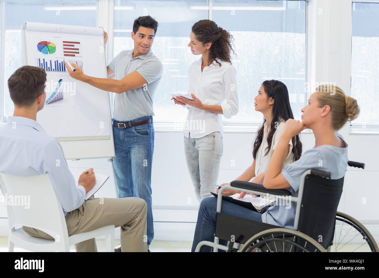 Casual Geschäftsmann eine Präsentation halten an die Kolleginnen und Kollegen im Büro Stockfoto