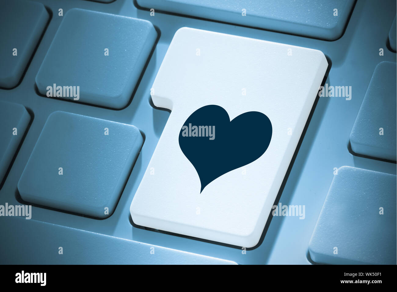 Herz gegen weiße ENTER-Taste auf der Tastatur Stockfoto