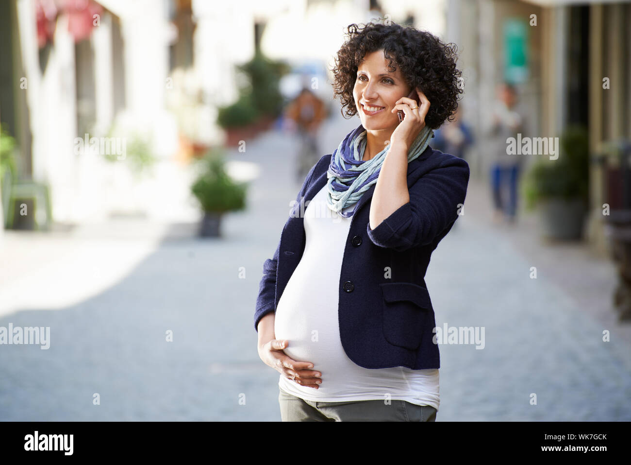Happy People und Lifestyle mit schwangere Frau im Gespräch mit Handy in Stadt Straße Stockfoto