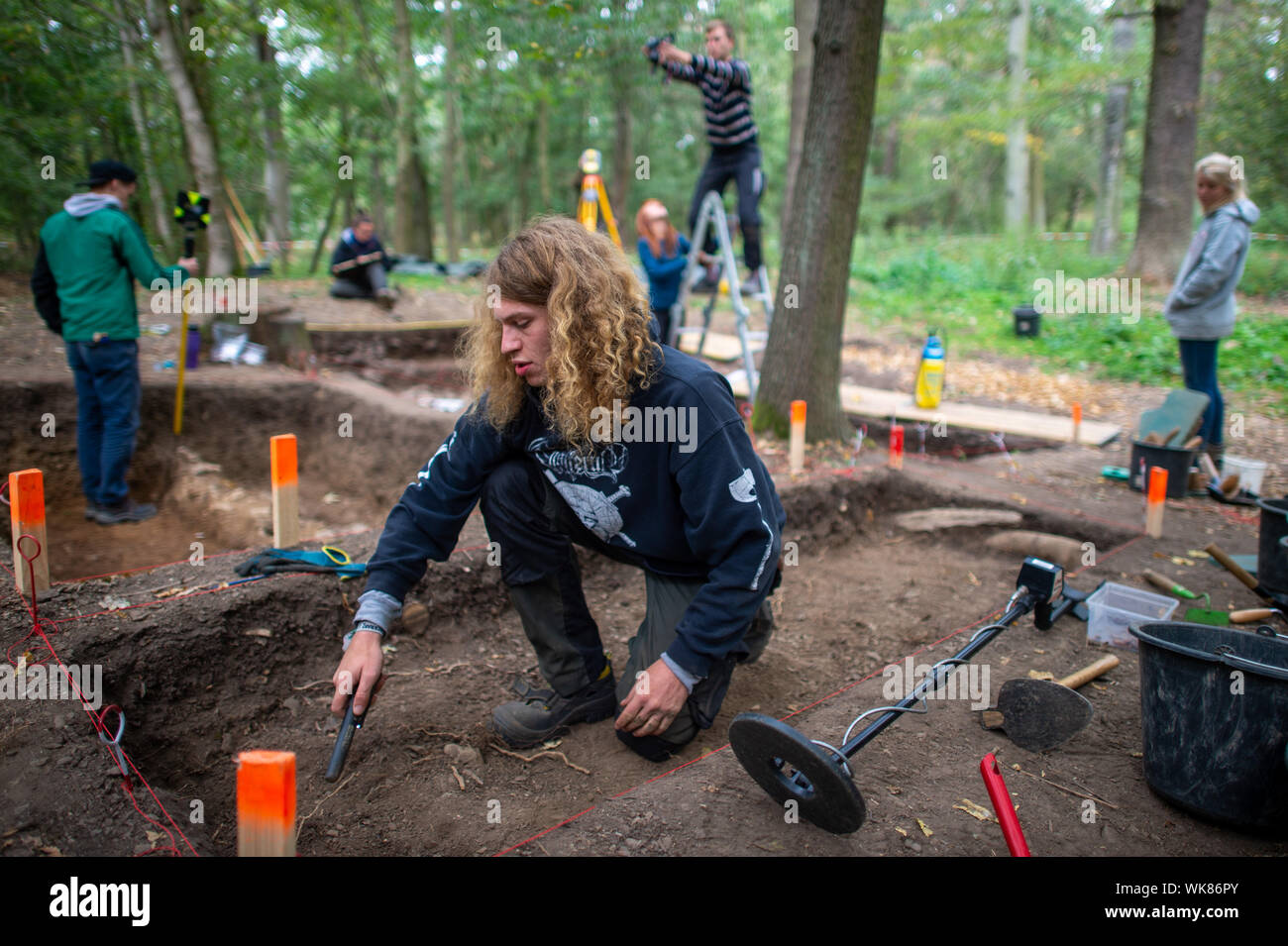 03 September 2019, Sachsen-Anhalt, Güntersberge: Eine Archäologie student verwendet einen Metalldetektor den Boden an der "Wüstung Anhalt' Ausgrabungsstätte zu prüfen. Die Siedlung bedeckt etwa 11 Hektar und wurde zwischen dem 11. und dem 12. Jahrhundert gegründet. Das Dorf verlassen wurde bereits im 15. Jahrhundert. Das Dorf ist eine von ungefähr 100 im Harz, die während des Mittelalters verschwunden und sind nun verlassenen Gebieten genannt. Die Ausgrabungen sind wichtig, weil es kaum haben systematische Untersuchungen im östlichen Harz so weit gewesen. (Dpa' findet von verlorenen Dorf in der Nähe von ballenstedt Stockfoto