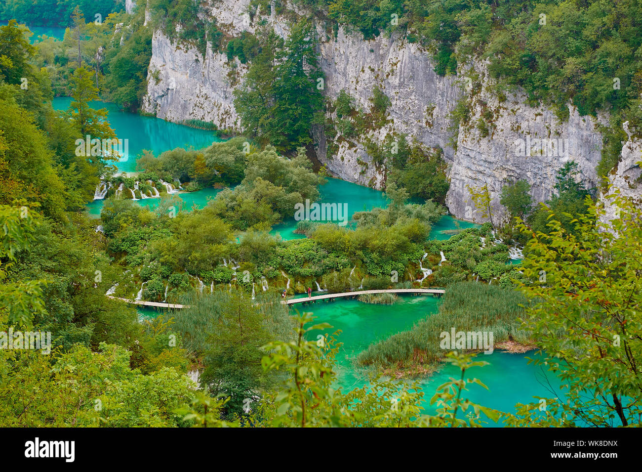 Fußgängerbrücke über türkisfarbenen See Stockfoto