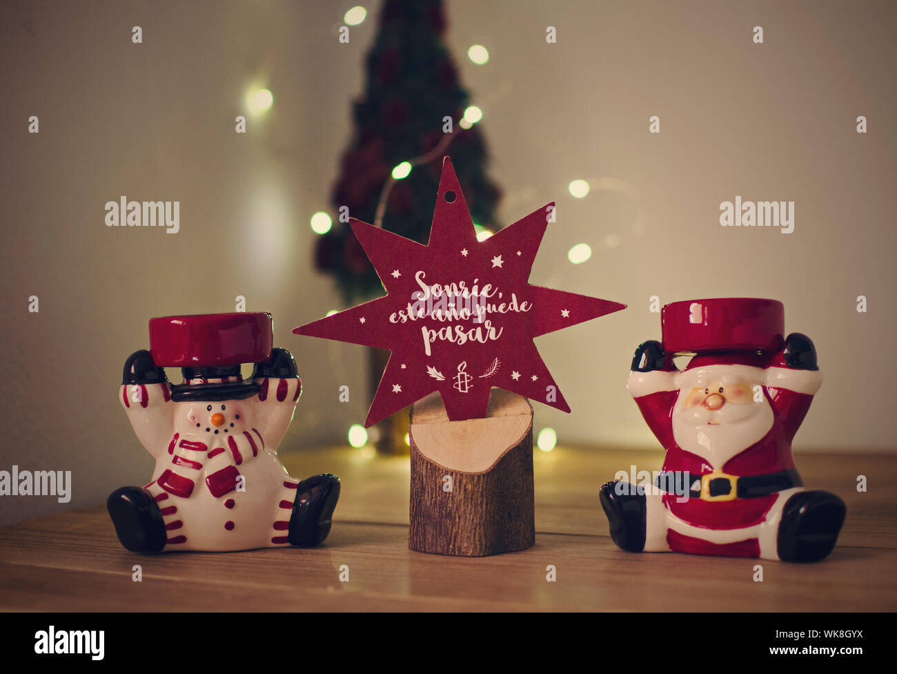 Minimalistische Weihnachten Dekoration auf einem Holztisch. Red Star mit Text in Spanisch (1,6 Km, es in diesem Jahr passieren kann). Bokeh, Unschärfe im Hintergrund Stockfoto