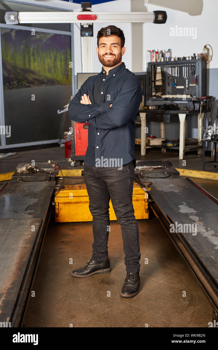 Zufrieden Mechaniker oder Mechatroniker im Auto Werkstatt vor dem Lift  Stockfotografie - Alamy