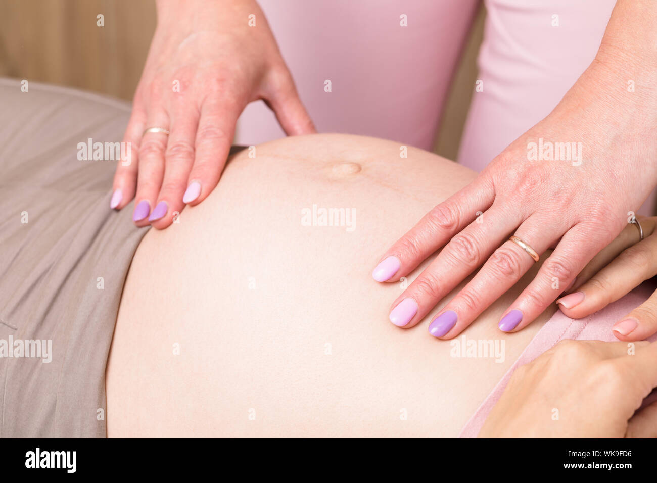 Nahaufnahme der Frauenarzt Frauenarzt untersucht manuell schwangeren Bauch pränatale Checkup durchführen Stockfoto