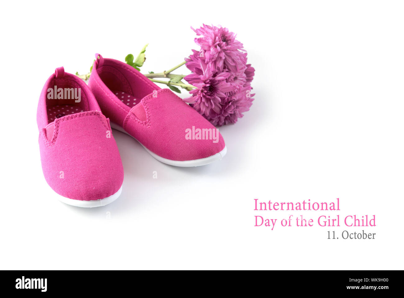 Rosa kid Schuhe und eine Blume auf einem weißen Hintergrund, Text Internationaler Tag der Mädchen 11. Oktober, Kopieren, ausgewählte konzentrieren Stockfoto