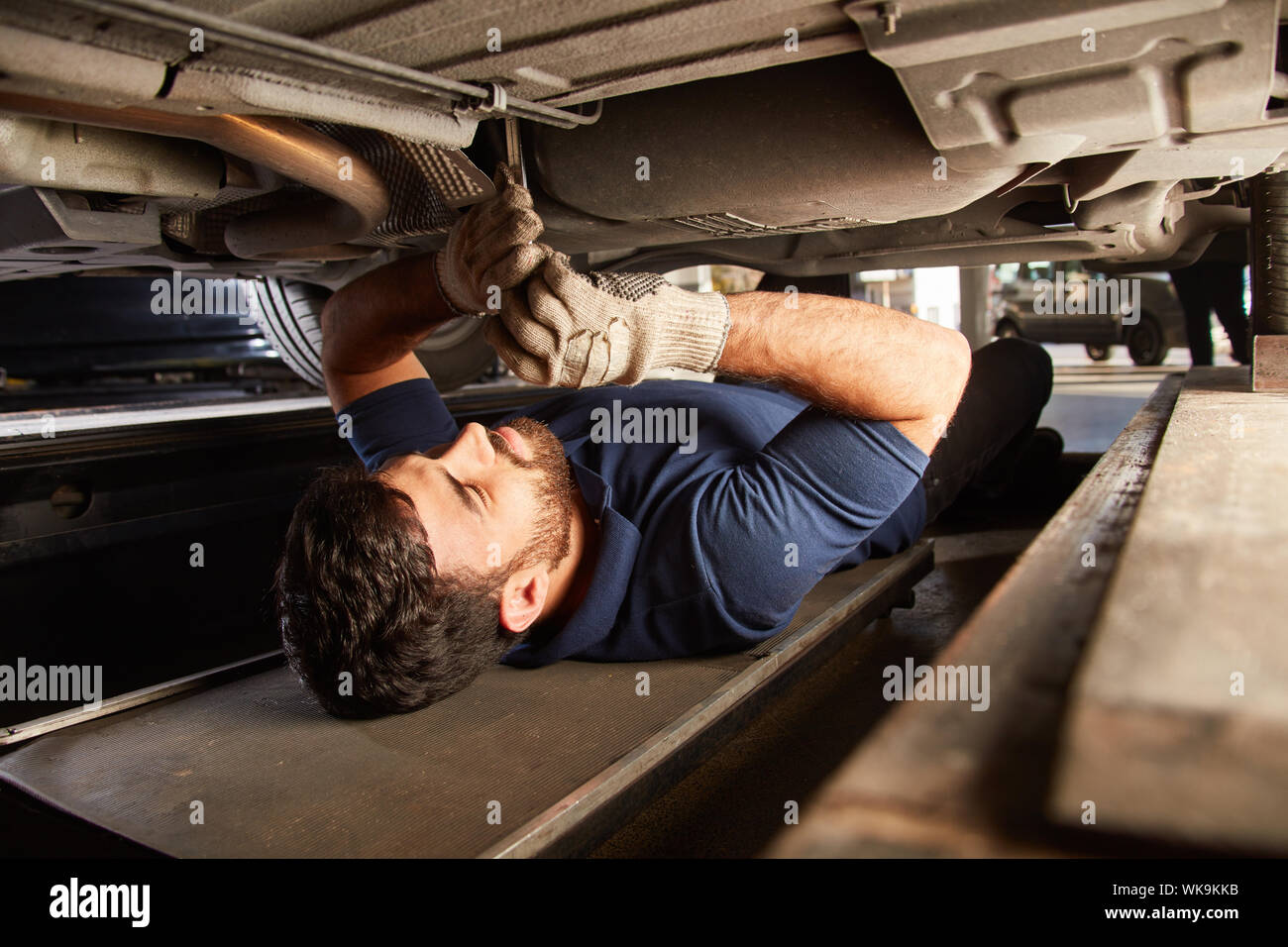 Automotive Mechatronics Engineer ist in der Reparatur oder Inspektion der Unterboden unter dem Auto Stockfoto