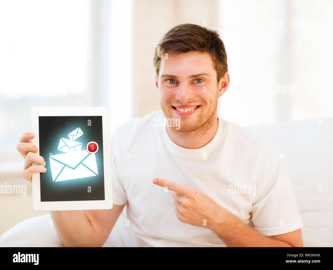 Mann, der Tablet-pc mit e-Mail-Zeichen zu Hause hält Stockfoto