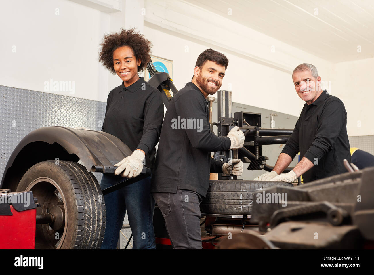 Junge multikulturelle Mechatronik Team bei Reifen in der Werkstatt Stockfoto