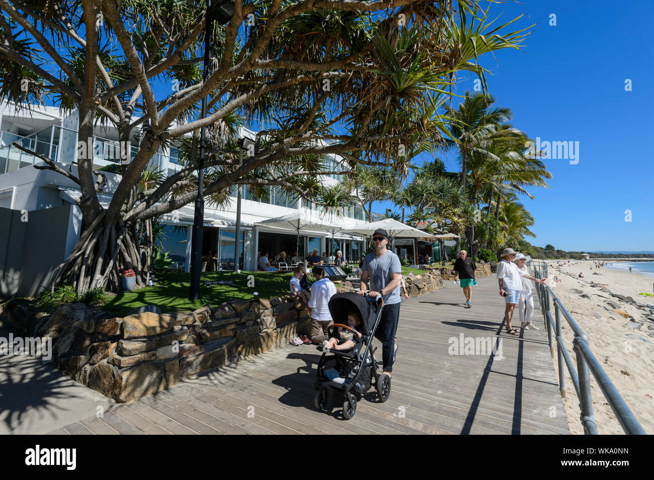 Vater treibt ein Baby Stroller in Noosa Heads, Esplanade, Queensland, Queensland, Australien Stockfoto