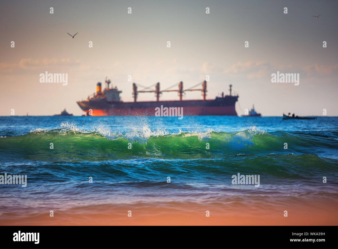Segeln Frachtschiff und Wellen bei Sonnenaufgang. Transport. Logistik. Versand Stockfoto