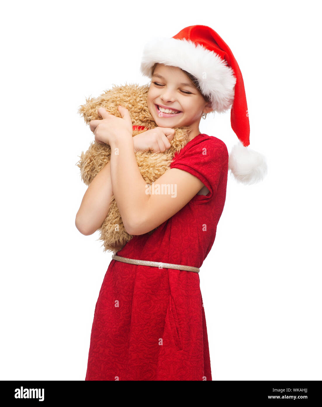 Weihnachten, Weihnachten, Winter, Glück Konzept - lächelndes Mädchen in Helfer Weihnachtsmütze mit Teddybär Stockfoto