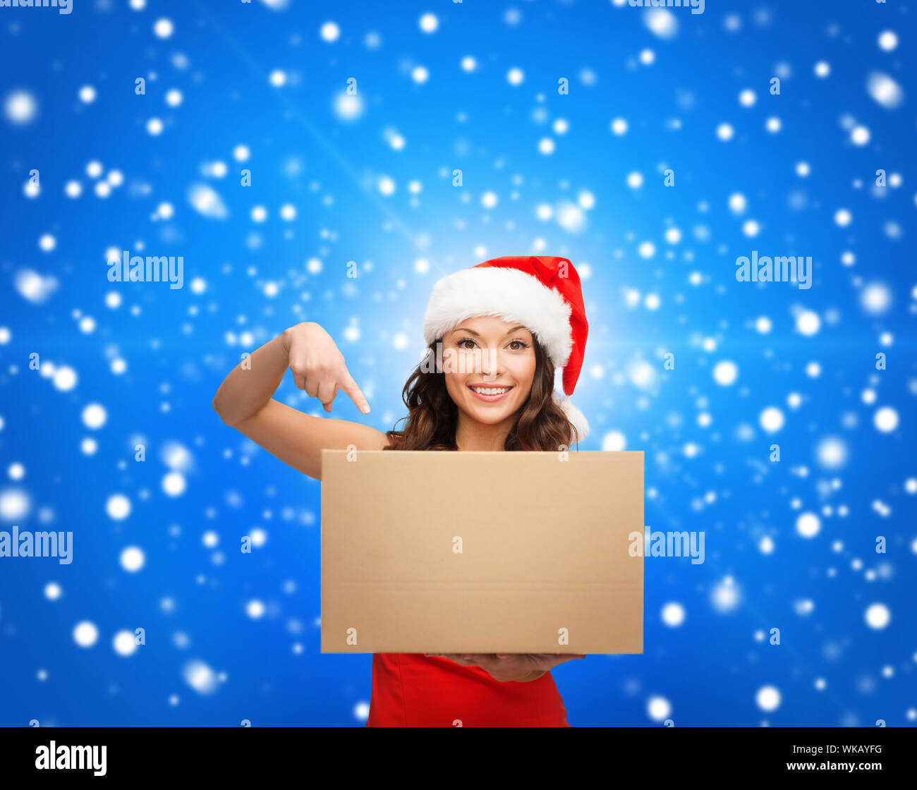 Weihnachten, Weihnachten, Winter, Glück Konzept - lächelnde Frau in Helfer Weihnachtsmütze mit Paketbox Stockfoto