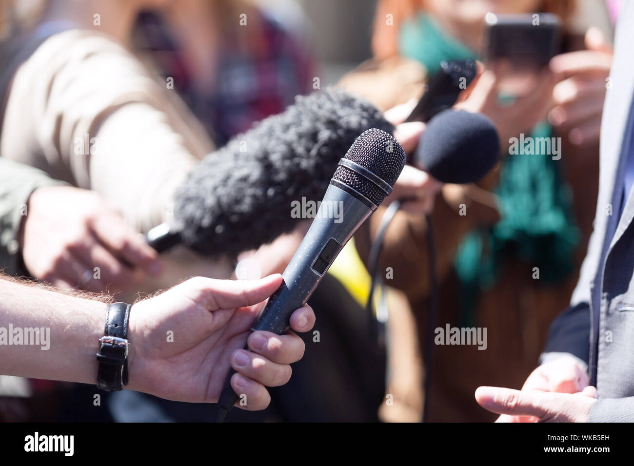 Zugeschnittenes Bild der Journalistin Holding Mikrofone Stockfoto