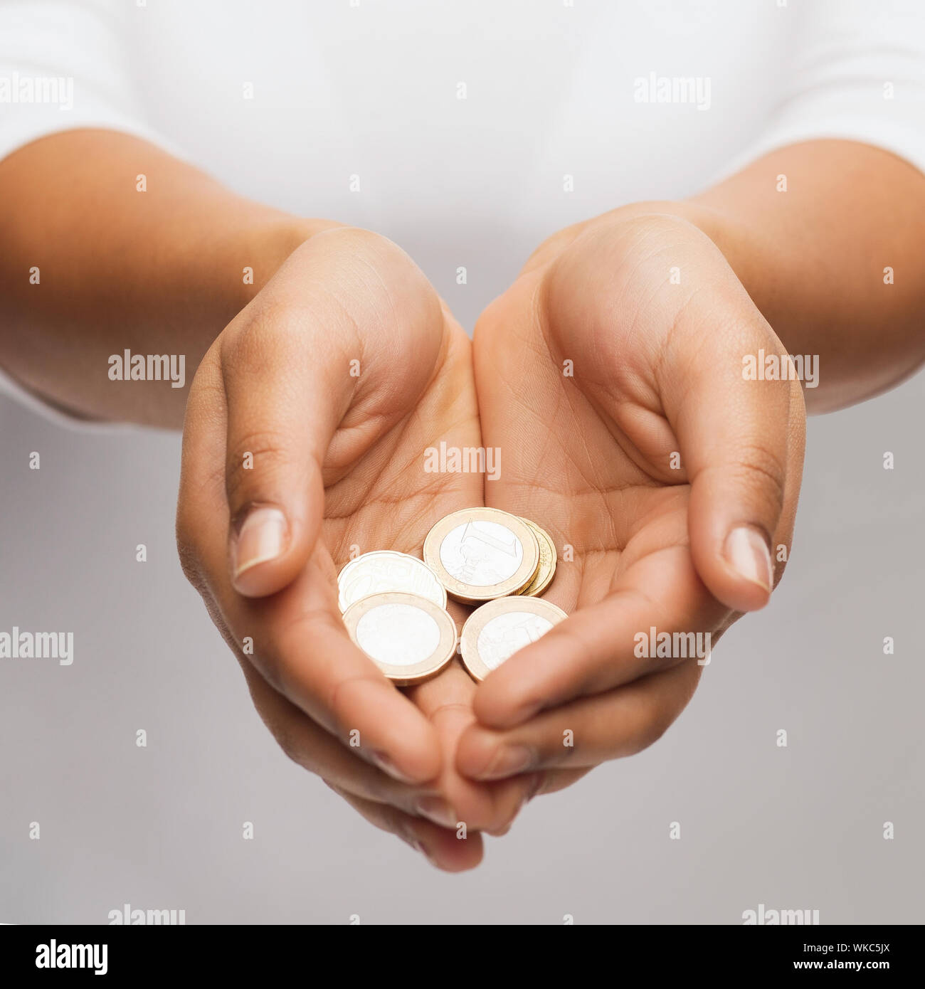 Womans schalenförmige Hände mit Euro-Münzen Stockfoto