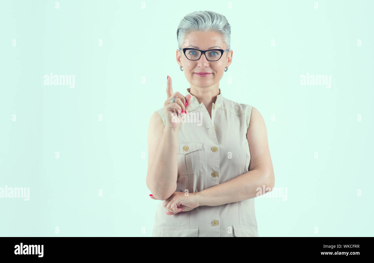 Achtung! Porträt einer Lehrerin mit Brille auf einem hellblauen Hintergrund. Wunderschöne reife Frau. Mittleren Alters. Stockfoto