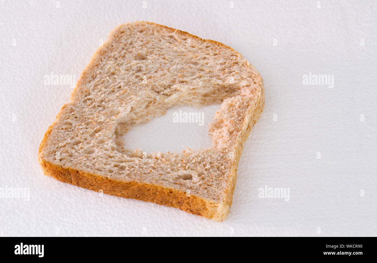 Eine Scheibe Brot mit ein Stück fehlt es auf einem weißen Hintergrund Bild mit Kopie Raum isoliert Stockfoto
