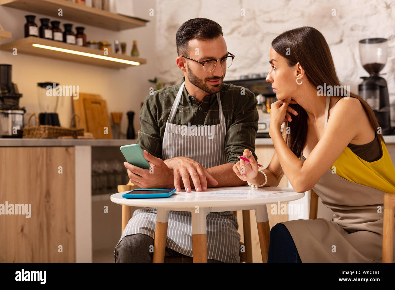 Paar Diskussion haben. Junge gut aussehende Paar Diskussion während der eigenen Cafeteria öffnen Stockfoto