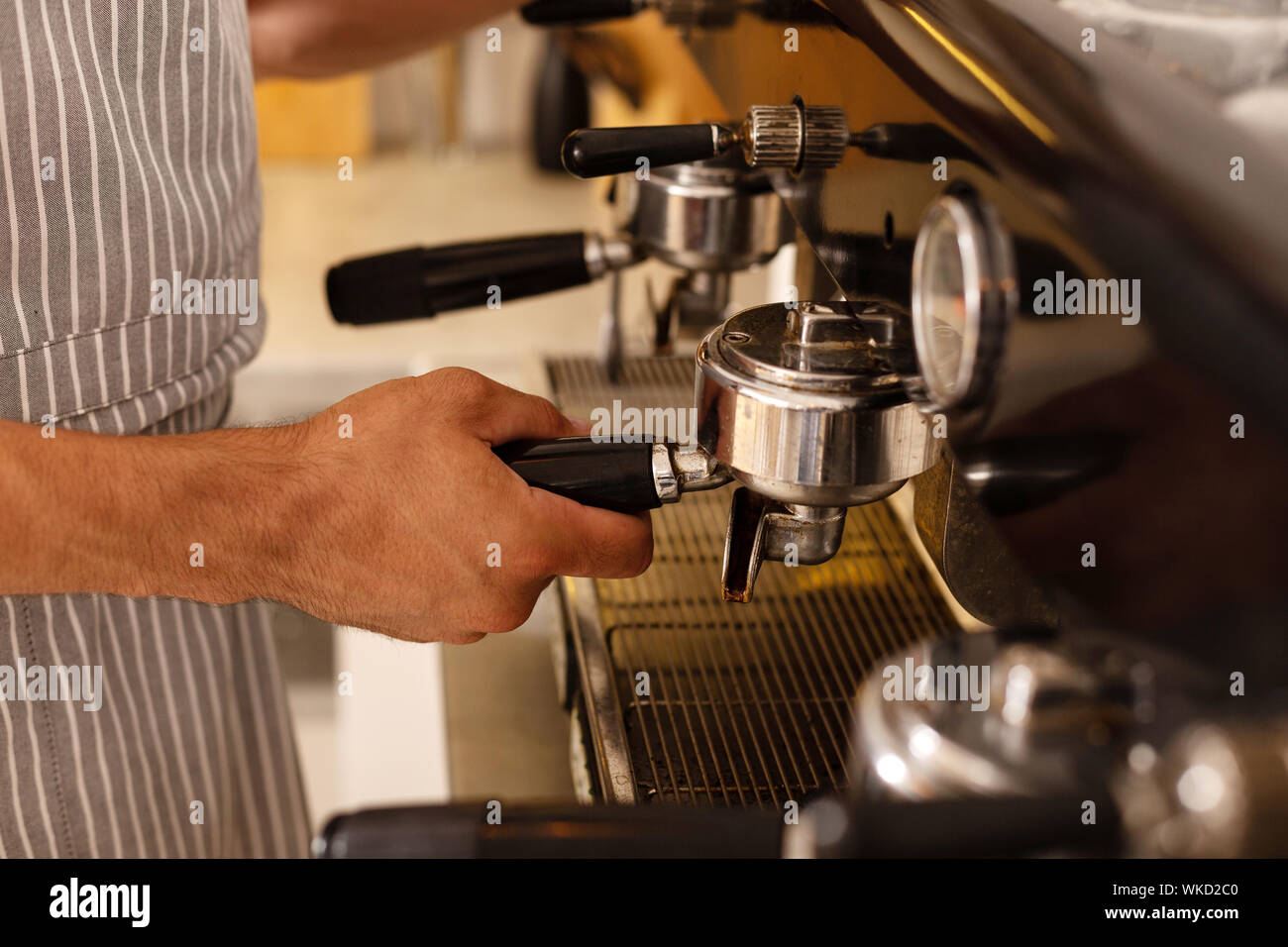 Barista. Nahaufnahme von Barista tragen gestreifte Schürze, Kaffee für Kunden am Morgen Stockfoto