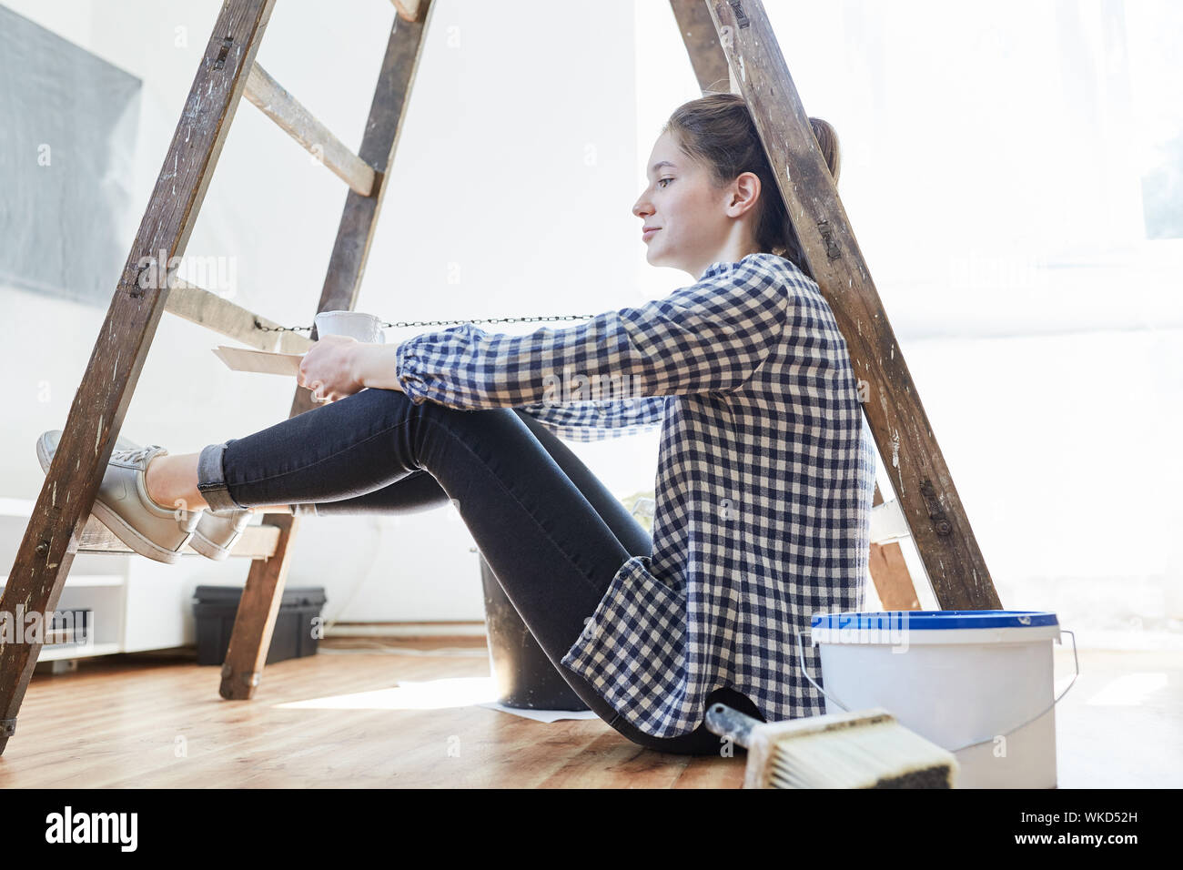 Eine junge Frau als Home Improvement ist eine Pause, während Ihr neues Zuhause renovieren Stockfoto