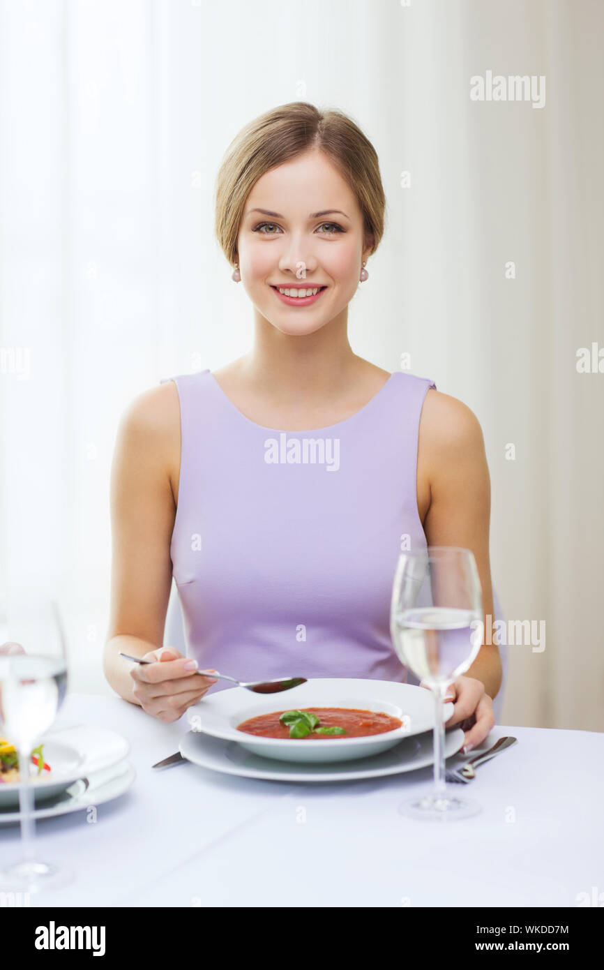 lächelnde junge Frau Aperitif im Restaurant Essen Stockfoto