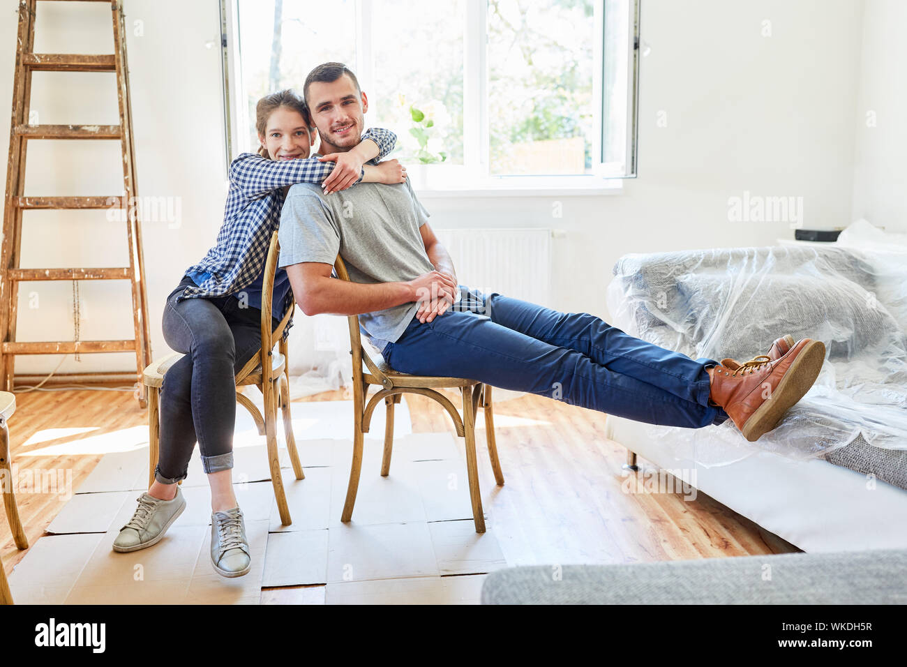 Glückliches junges Paar freut sich auf eine Pause während zu Hause renovieren Stockfoto
