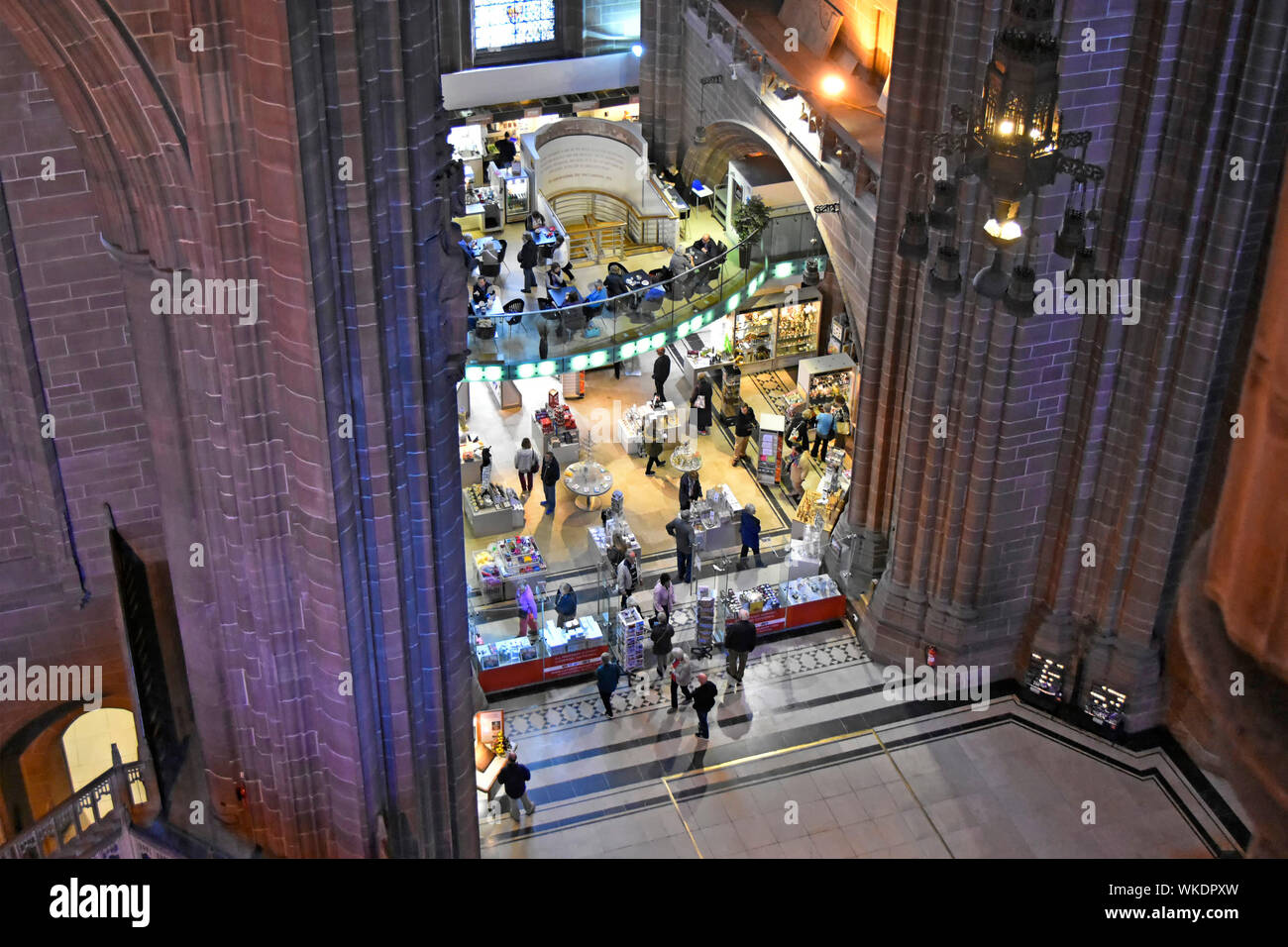 Aus der Vogelperspektive mit Blick von hoch oben auf die Leute, die im Souvenirladen und im Café im Schiff der Liverpool anglikanischen Kathedrale einkaufen. Farbige Wandbeleuchtung England Großbritannien Stockfoto