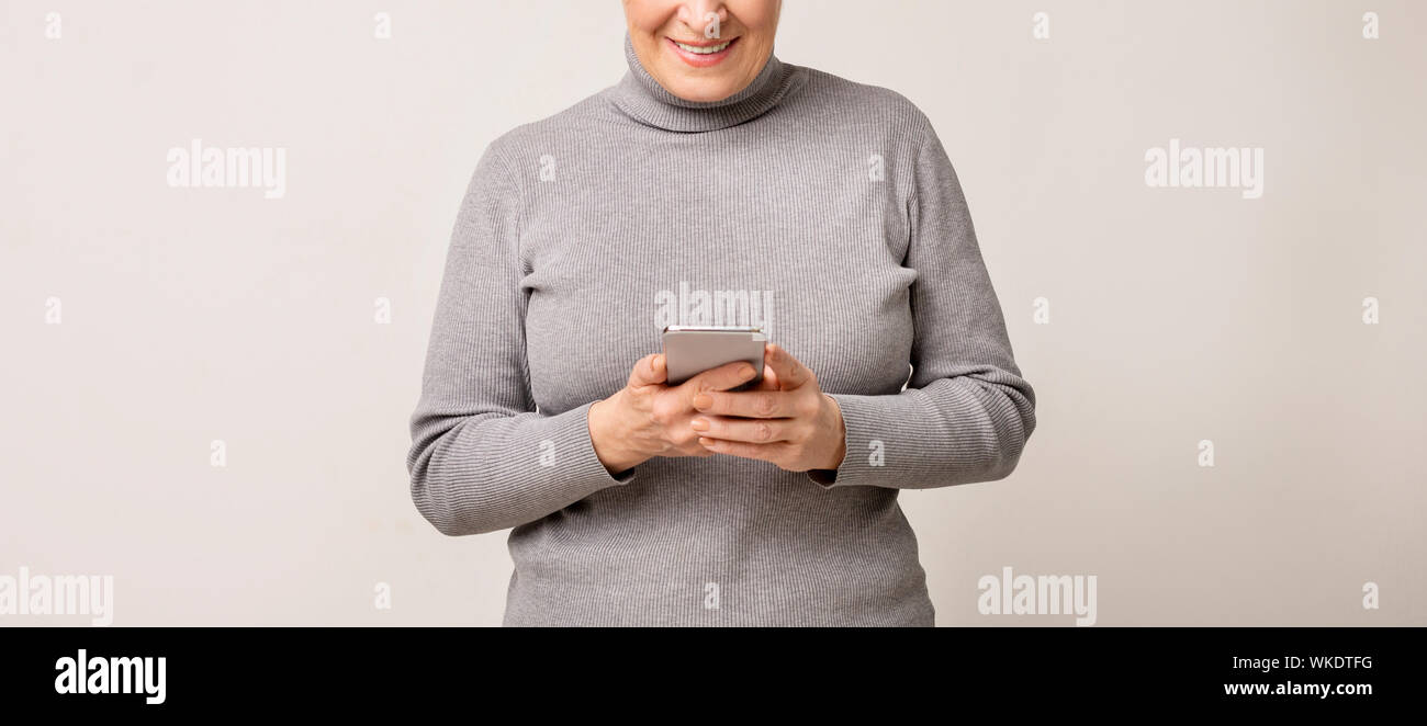 Ältere Frau mit modernen Handys, surfen Sie im Internet Stockfoto