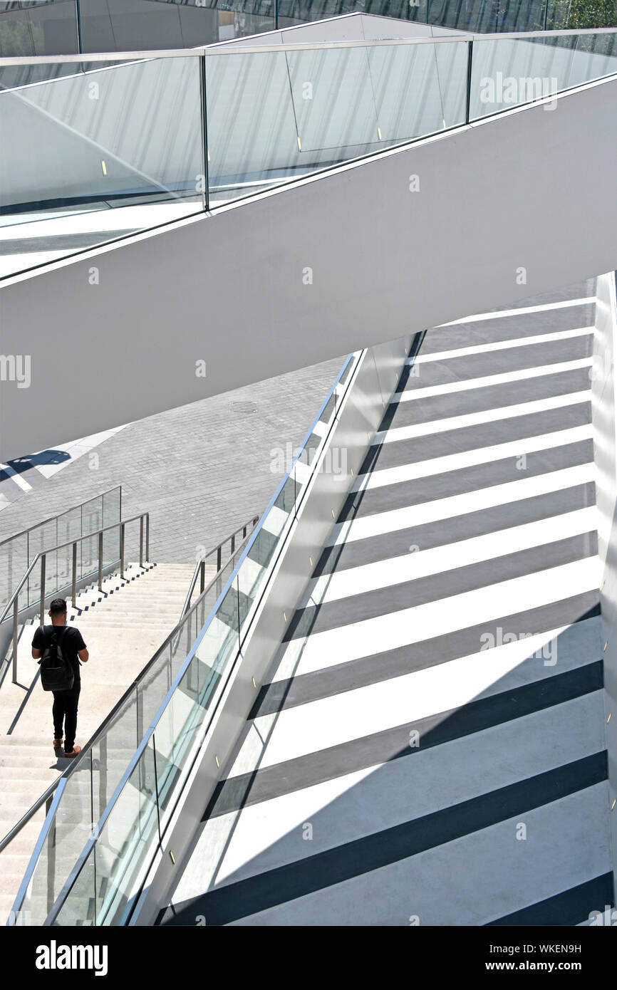 Rückansicht der Mann allein gehen, Schritte von Gehwegen und Rampen an "Die Flut" ein linearer Park von erhöhten Spaziergänge über North Greenwich London England Großbritannien Stockfoto